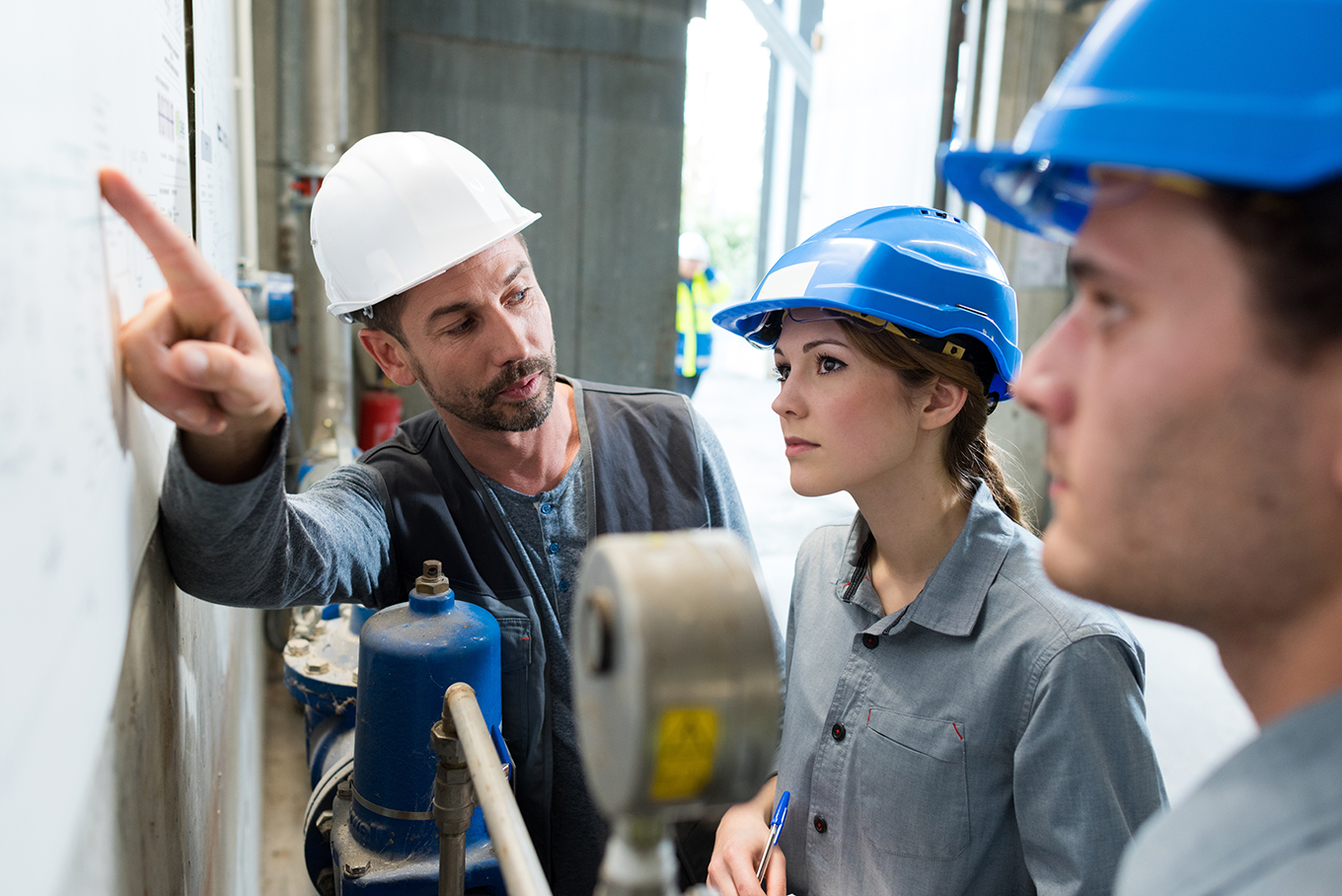 Image pour Explorez les métiers - Un technicien supérieur de sexe masculin dispense une formation à un jeune apprenti, homme et femme.