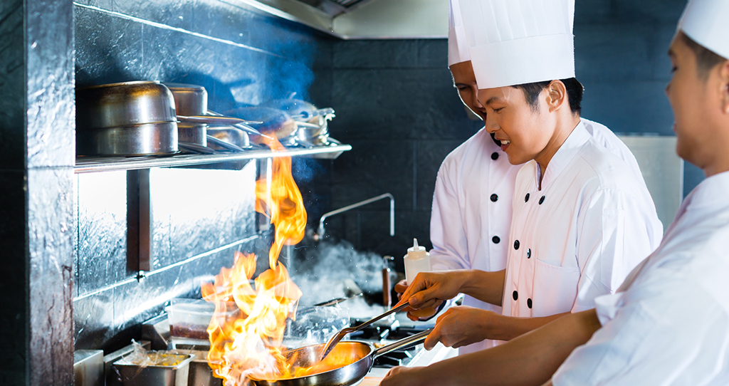 Image pour l'évaluation de l'équivalence commerciale, un cuisinier faisant sauter au feu.