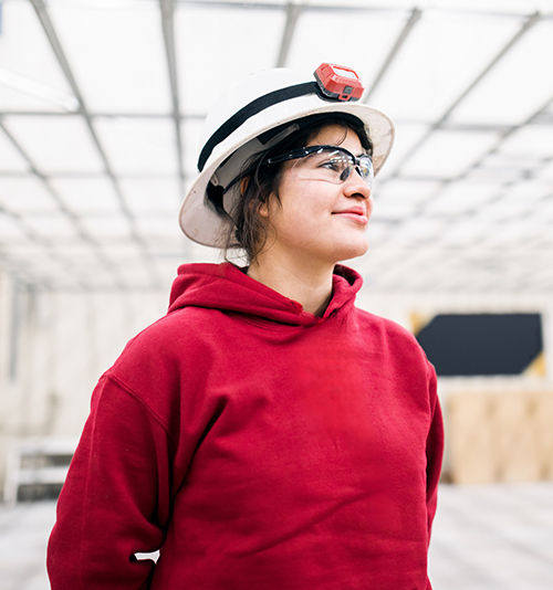 Image pour les futurs apprentis - Une jeune commerçante debout.