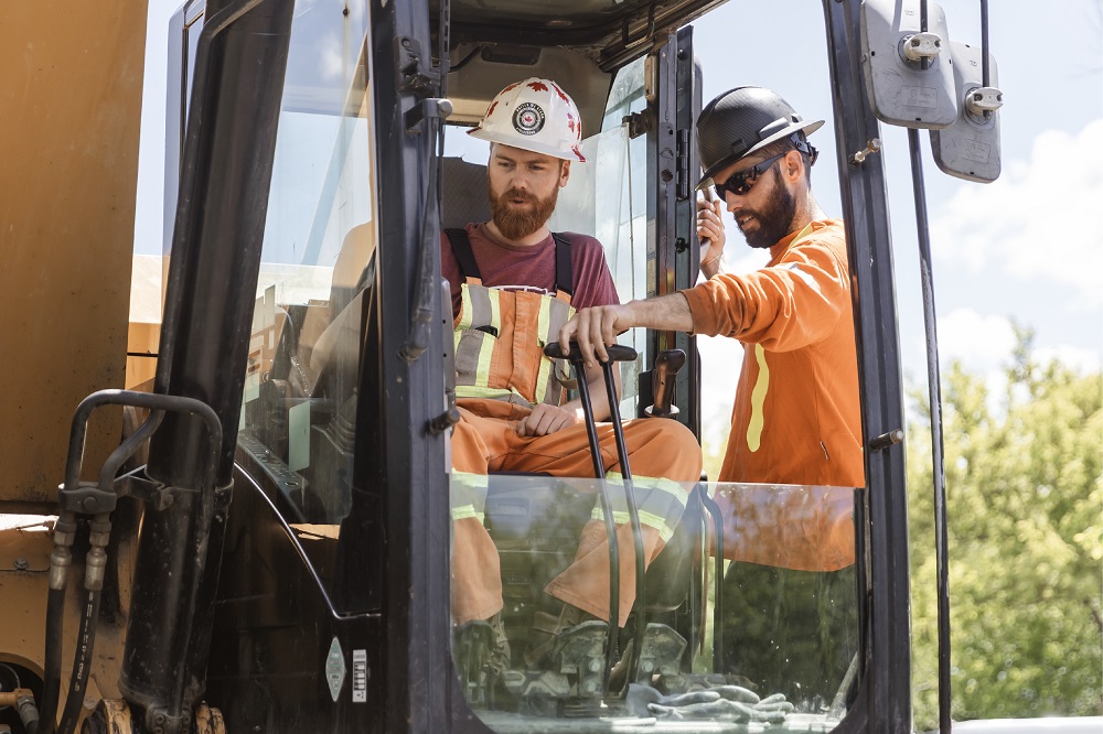 A male apprentice is being trained by a male senior staff.